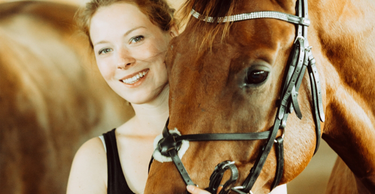 Ung kvinna med en häst.