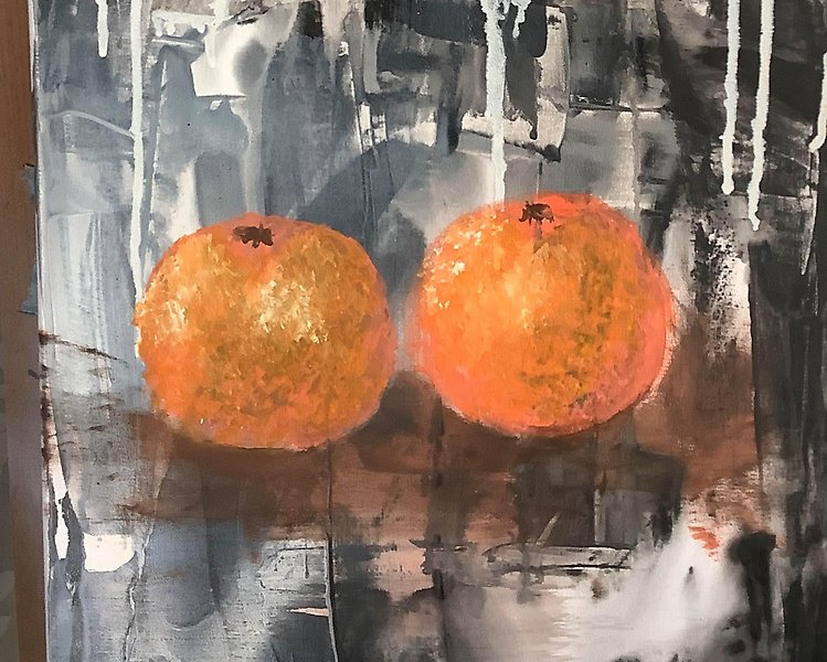 Två målade apelsiner på mörk makgrund